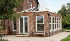 Large red brick orangery with white uPVC windows