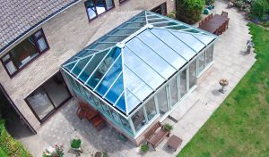 Sage green Edwardian uPVC conservatory with a glass roof